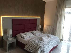レッチェにあるS'Oronzo Modern Town Houseのベッドルーム1室(赤いヘッドボード付きの大型ベッド1台付)
