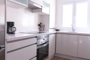 biała kuchnia ze zlewem i kuchenką w obiekcie ConK Apartments by CasaTuristica w mieście Ronda