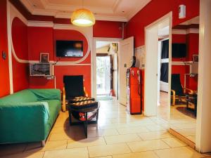 uma sala de estar com um sofá verde e uma parede vermelha em Deeps Hostel Ankara em Ancara