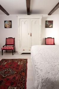 a bedroom with a bed and two red chairs at Maison Cirmi in Szabadhidvég