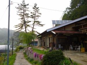 a house with a fence next to a street at Minshuku Yurika in Urugi