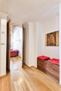 トリノにあるLoft dei Mercantiの赤いシーツが敷かれたベッドが備わる客室です。