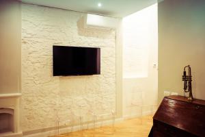 un muro in pietra con TV a schermo piatto a parete di Rodolfo Suite a Firenze