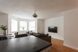 a living room with a couch and a table at Stunning Contemporary Apartment - Free Parking - 5 Minute Walk To The Beach - Great Location - Fast WiFi - Smart TV With Netflix Included - Perfect For Short and Long Stays in Bournemouth