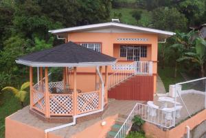 a small orange house with a gazebo at Golden Apple Cottage in Castara