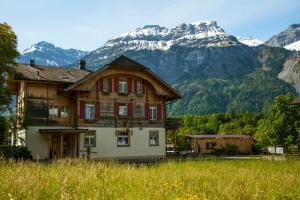 une vieille maison en face d'une montagne dans l'établissement Hotel Alpenrose beim Ballenberg, à Brienz