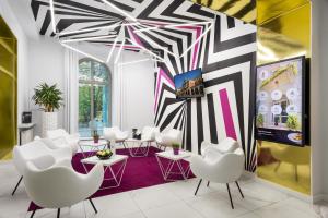 a room with white chairs and a wall with black and white stripes at Best Western Plus Krakow Old Town in Kraków