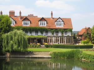 a large house with a pond in front of it at The French Horn in Reading