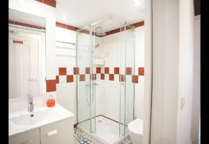 a bathroom with a glass shower and a sink at Atalaia Home in Lisbon