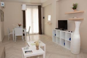 Una sala de estar con un televisor y una mesa. en Bosco Sea Apartments, en San Leone