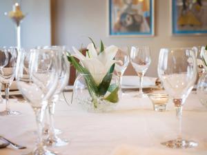 a table with wine glasses and a vase of flowers at Hotel MS Maestranza Málaga in Málaga