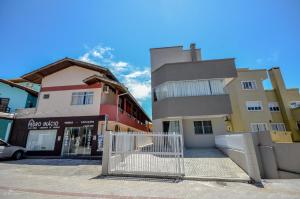 a white gate in front of a building at Residencial Costa Marfim in Bombinhas