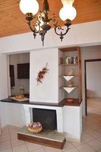 a living room with a fireplace and a chandelier at Pelion Orama in Agios Ioannis Pelio