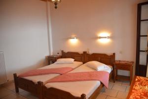 two beds in a room with two lamps on the wall at Pelion Orama in Agios Ioannis Pelio