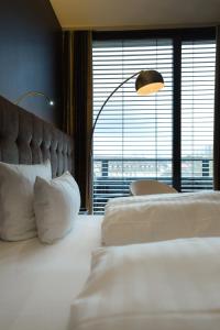 a bedroom with two beds and a large window at SAKS Urban Design Hotel Kaiserslautern in Kaiserslautern