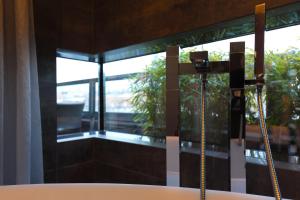 uma casa de banho com uma banheira e uma janela em SAKS Urban Design Hotel Kaiserslautern em Kaiserslautern