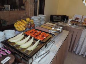 Hotel Costa Balena-Piscina Aquecida Coberta في غوارويا: بوفيه فيه فواكه وخضار على طاولة