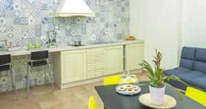 une cuisine avec des armoires jaunes et une table avec des beignets. dans l'établissement B&B Domus Purpurea, à Rossano