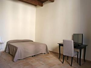 1 dormitorio con 1 cama, 1 mesa y 1 silla en B&B Domus Purpurea en Rossano