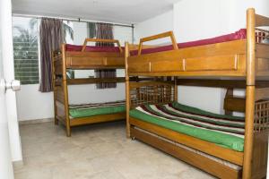 ein Zimmer mit drei Etagenbetten und einem Fenster in der Unterkunft Apartamento con playa privada y piscina in Santa Marta + 19 Fotos