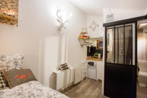 um pequeno quarto com uma cama e uma cozinha em Nid du Parc - Parfait 1 personne em Lyon