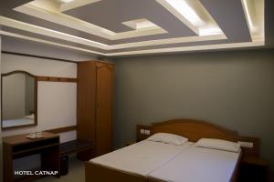 1 dormitorio con 1 cama y tragaluz en Hotel Catnap, en Mettuppālaiyam