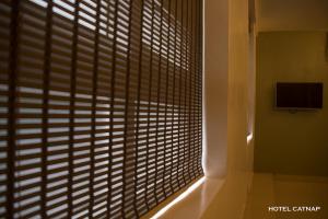 a window with wooden blinds in a room at Hotel Catnap in Mettuppālaiyam