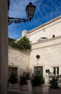 un bâtiment avec des plantes en pot sur son côté dans l'établissement Corte Borromeo, à Mandurie