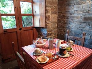 a table with a red checkered table cloth with food on it at El Rincón del Cuco in Tejedo de Ancares