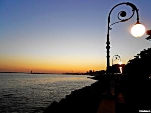 a street light next to the water at sunset at Hopps Studio in Mazara del Vallo