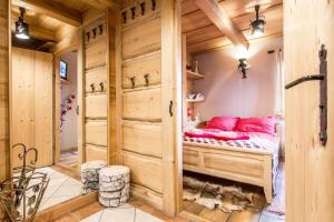 a room with a bed in a wooden cabin at Apartament Kominkowy Deluxe Zakopane in Zakopane