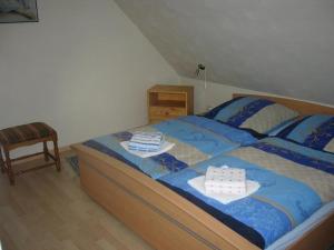 アルテンアウにあるHarzhaus-am-Brunnen-Wohnung-4のベッドルーム1室(青い掛け布団、椅子付)
