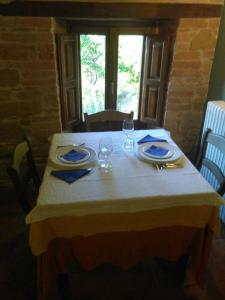 a table with a white tablecloth and glasses on it at Terra di Magie in Sarnano