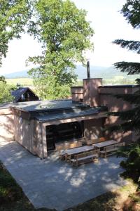 ein Gebäude mit einem Kamin und Bänken davor in der Unterkunft Vila Lom in Velké Losiny