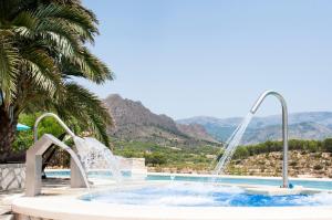 una piscina con una fuente de agua en un complejo en Finca El Almendral, en Relleu