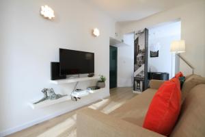 uma sala de estar com um sofá e uma televisão de ecrã plano em Alfama Right Point em Lisboa