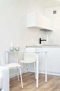 ワルシャワにあるWarsaw Concierge Rondo ONZの白いキッチン(シンク、白い椅子付)