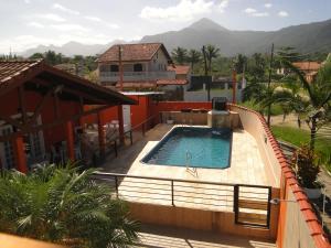 a swimming pool in front of a house at Pousada Gaivotas in Peruíbe