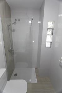 a white bathroom with a shower and a toilet at Magnifica Oportunidad, junto a la Playa y al Teatro Falla in Cádiz