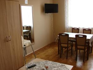 comedor con mesa, sillas y espejo en Krovo Apartments en Cracovia