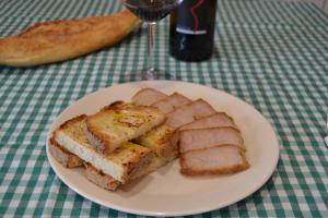 un plato de comida con pan y una copa de vino en El Trasgu de Foncebadón en Foncebadón