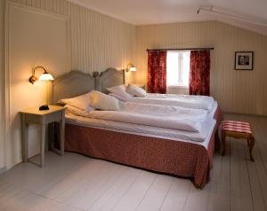 a bedroom with a large bed and a table and a window at Rundhaug Gjestegard in Rundhaug