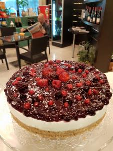 a large cake with berries on top of it at Hotel La Quercia in Valmontone