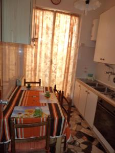 eine Küche mit einem Tisch mit Stühlen und einem Fenster in der Unterkunft A cà du Piero in Albisola Superiore