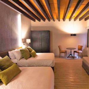Cette chambre comprend 2 lits et une table. dans l'établissement Othelo Boutique Hotel Mexico, à León
