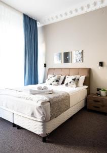 - une chambre avec un grand lit blanc et des rideaux bleus dans l'établissement Hotel Hötorget, à Stockholm