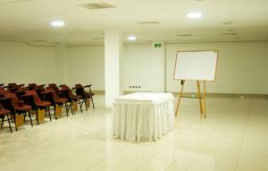 a conference room with a white table and chairs at Apartaestudios Los Andes in Bogotá