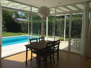 a dining room with a table and chairs and a pool at Casa en la Ruta del Malbec in Las Compuertas