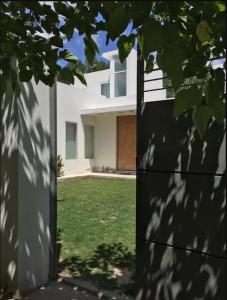 a white house with a yard with green grass at Casa en la Ruta del Malbec in Las Compuertas