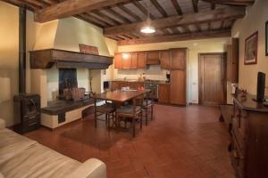 eine große Küche mit einem Tisch und einem Kamin in der Unterkunft Guido's House in Castiglion Fiorentino